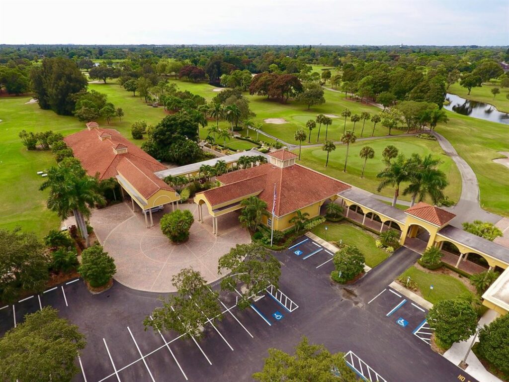 The club features a championship 18-hole golf course, a clubhouse with dining and event space, swimming pools, tennis courts, and other recreational facilities.