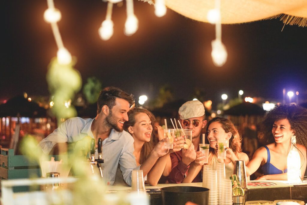 The perfect picture of Anna Maria Island's nightlife - friends gathering around a bar with drinks in hands, having fun