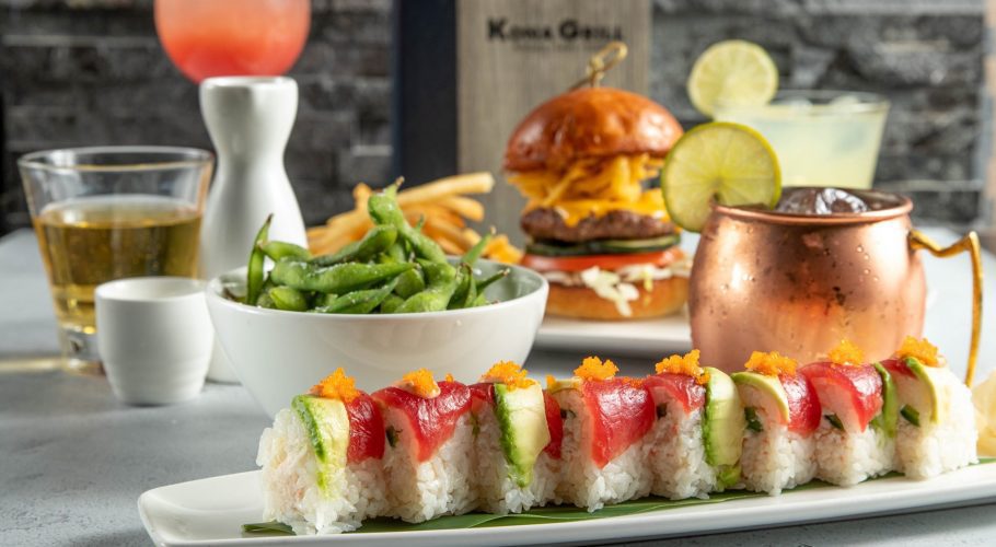A plate of sushi with a burger and fries, a side of edamame, and a cold drink - a variety in the menu options at the Kona Grill in Sarasota