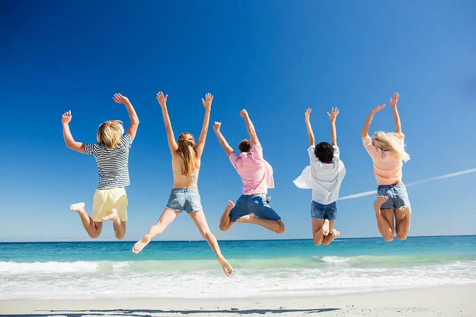 A family of 5 having the best time, jumping together on Navarre Beach