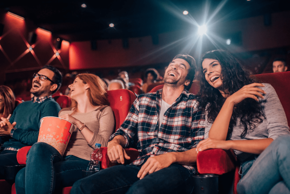 Couples and groups of friends laughing and having fun, while watching a movie at AMC Bradenton cinema