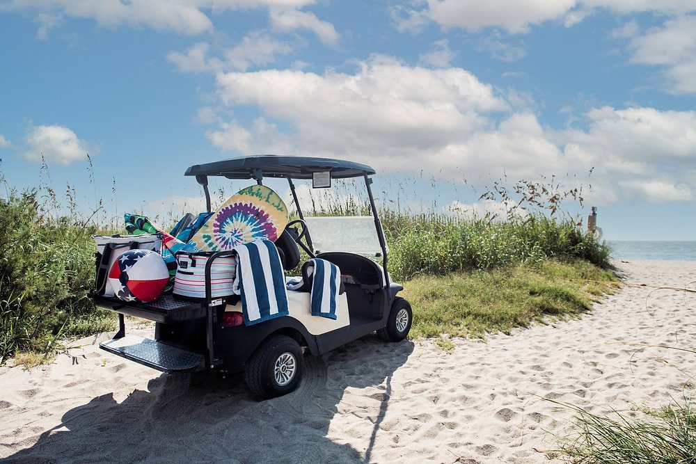 A golf cart, filled with beach supplies, parked right by the beach. Golf carts really are the best form of transportation on Anna Maria Island