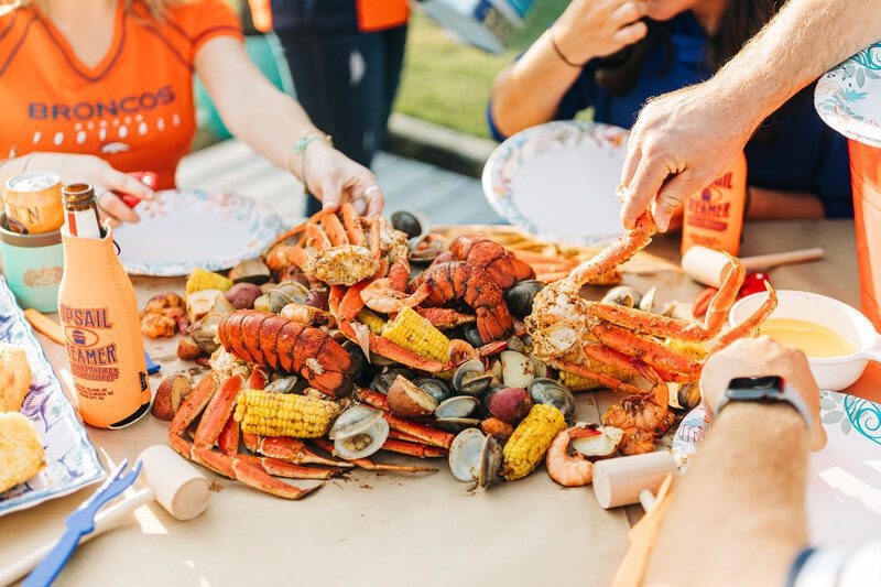 A colorful assortment of lobster, shrimp, crab, corn, and many other seafood, offered by Topsail Steamer's unique steamed buckets and pots.